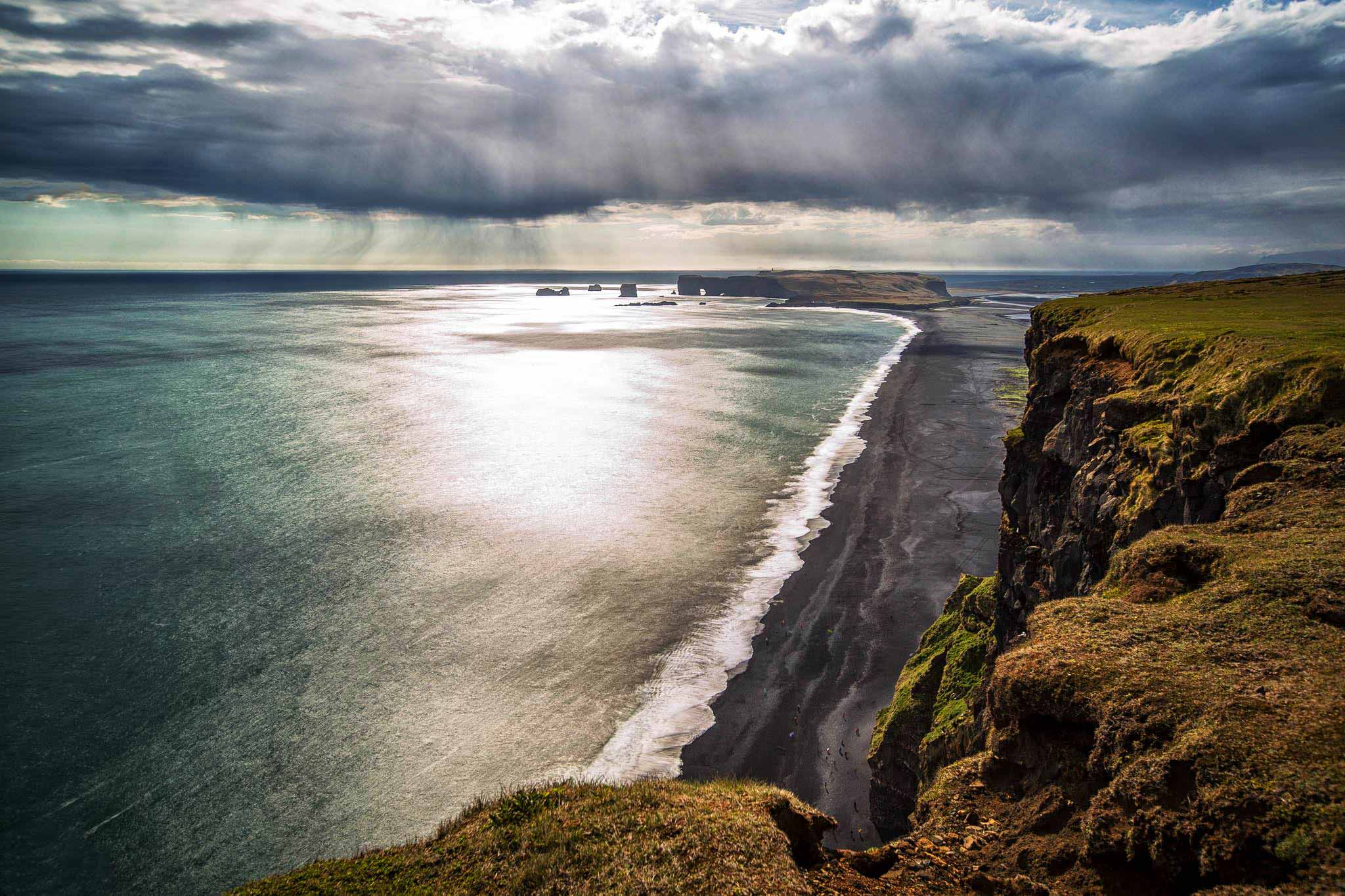 View from Dyrhólaey headland looking over Vík's black sand beach toward the Reynisdrangar sea stacks, south Iceland
